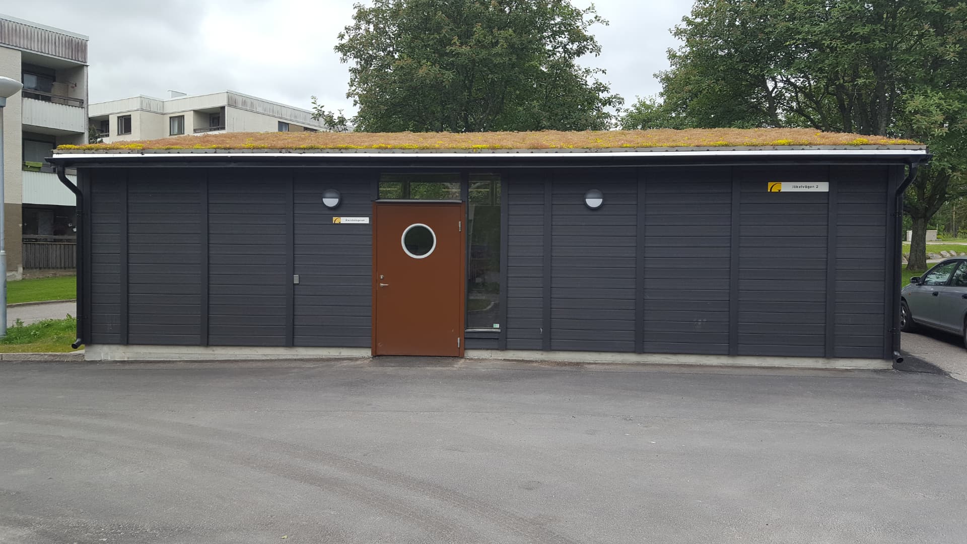 Miljøhus med sedumtag og mørkegrå facade leveret til en bolig ejendom